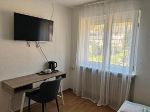 a room with a desk and a window with a monitor at Haus Sissi in Daun