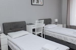 a room with two beds and a desk with a desk at Rakhiv Hotel & Apartments in Rakhiv