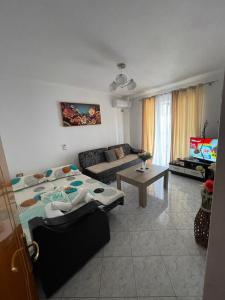 a living room with a couch and a table at Summerland Lukovë in Sarandë