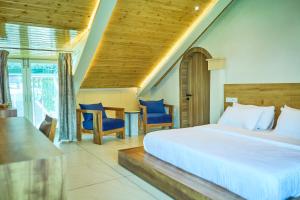 a bedroom with a bed and a table and chairs at Ruscello in Pālampur
