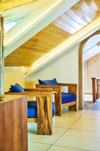 a dining room with wooden tables and blue seats at Ruscello in Pālampur