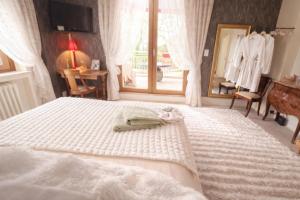 a bedroom with a white bed with a mirror at Chambres d'hotes la forêt in Longwy