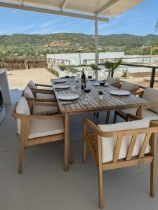 a wooden table and chairs with wine glasses on a patio at Casa rural Doble-R in Ronda