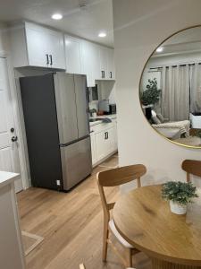 a kitchen with a refrigerator and a table and a mirror at Chic East LA Retreat 2 bedroom-sleeps 6-Near DTLA-Car Rental Service on Property in East Los Angeles