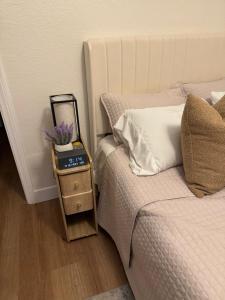 a bedroom with a bed and a night stand with a mirror at Chic East LA Retreat 2 bedroom-sleeps 6-Near DTLA-Car Rental Service on Property in East Los Angeles