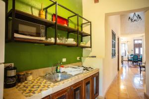 a kitchen with a sink and a green wall at Historical Green House Campeche in Campeche +52 photos