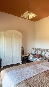 a bedroom with a bed and a cabinet and a couch at Villa Fè -Choose Panoramic View, Jacuzzi, Private Parking in Montepulciano +8 photos