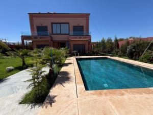 a house with a swimming pool in front of a house at Villa Golden Sun in El Jemʼa Ghemat