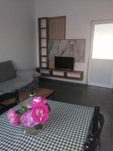 a living room with a table with pink flowers on it at Holiday house in Laknas +7 photos