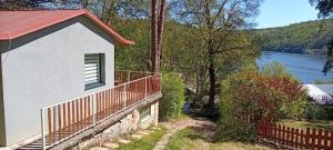 a house with a fence next to a body of water at Chata Bítov in Bítov +10 photos