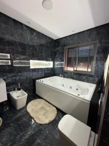 a bathroom with a tub and a toilet and a sink at Villa Golden Sun in El Jemʼa Ghemat +14 photos