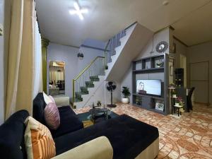a living room with a couch and a tv at AJM Iligan Homestay in Saray