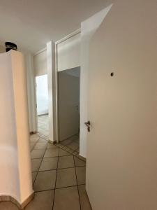 an empty hallway with a door and a tile floor at B&B bellinzona gino in Bellinzona +1 photo