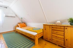 a room with a bench and a dresser in a attic at Két Fenyőfa Vendégház Vízparti Nyaraló in Békésszentandrás
