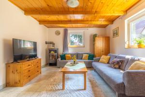 a living room with a couch and a tv at Két Fenyőfa Vendégház Vízparti Nyaraló in Békésszentandrás
