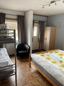a bedroom with two bunk beds and a chair at Målerås B&B Guesthouse in Målerås
