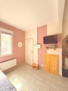 a bedroom with a bed and a flat screen tv at La petite Escapade in Calais