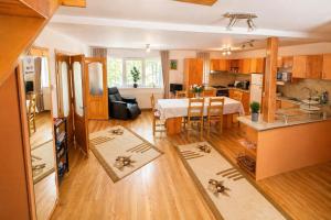 a kitchen and a living room with a dining table at Apfelhaus Poiana Marului in Poiana Mărului