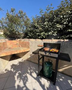 a barbecue on a table next to a bench at Escales du Sud, Frontignan Plage in Frontignan