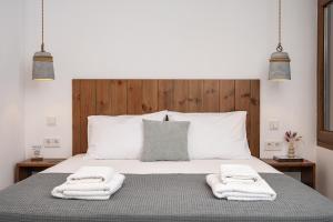a bedroom with a bed with towels on it at Kalami in Kokkari