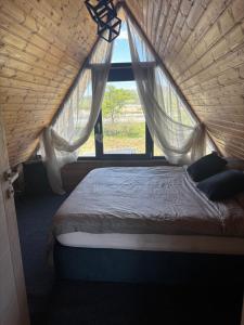 a bedroom with a large bed with a window at LAKEVIEW A-frame ESCAPE in Tisa