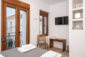 a bedroom with a bed and a desk and a television at Kalami in Kokkari