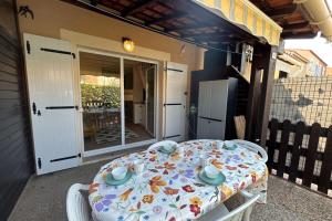 a table and chairs on a porch with a table and chairs at The beachside coquette in Frontignan