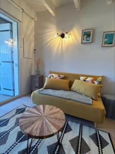a living room with a couch and a table at The beachside coquette in Frontignan +8 photos
