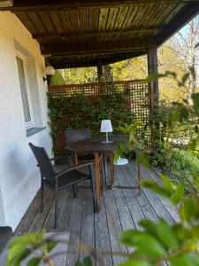 a wooden table and chairs on a porch with awning at Ferienhaus Rotzinger in Hinterzarten
