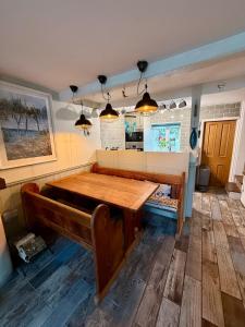 a dining room with a table and a bench at Oligrae Cottage in Bridport