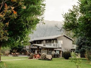 a house with a yard with chairs and trees at Similkameen Valley Resort in Cawston