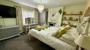 a bedroom with a bed with a television and a desk at Oligrae Cottage in Bridport