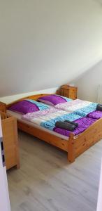 a bedroom with a wooden bed with purple sheets and pillows at Griesenstraße in Warendorf