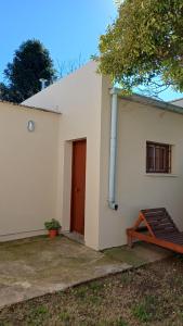 a white building with a red door and a porch at Departamento Salomé in Eduardo Castex