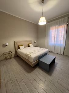 a bedroom with a bed and a table and a window at Respiro Di Mare in Torre del Greco