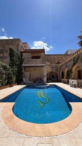a large swimming pool in front of a building at Stella & Stone Guesthouse in Għarb
