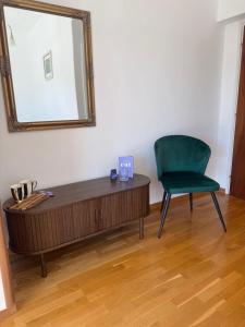 a mirror and a green chair in a room at Villa Misita Elegant SeaView Rooms in Dubrovnik