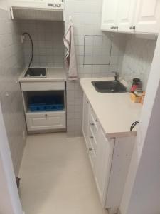 a small white kitchen with a sink and a counter at Soukromé ubytování 1 in Zlín