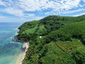 an island in the ocean with a house on it at Knox's Beachfront Homestay in Nalauwaki