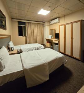 a hotel room with two beds and a desk at HERSH Palace Hotel in Erbil +44 photos