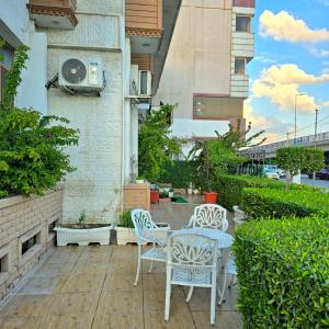 a patio with two chairs and a table on a building at HERSH Palace Hotel in Erbil