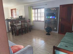 a living room with a couch and a table and chairs at Casa com Piscina Privativa e Churrasqueira in Araruama