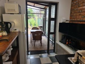 a kitchen with a door leading to a table with a tableablish at Deco Cottage in Centurion