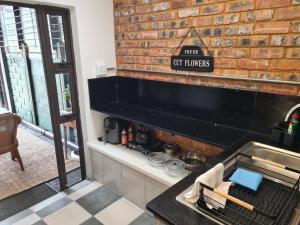 a kitchen with a stove and a sign on a brick wall at Deco Cottage in Centurion