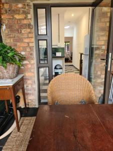 a dining room with a table and a brick wall at Deco Cottage in Centurion
