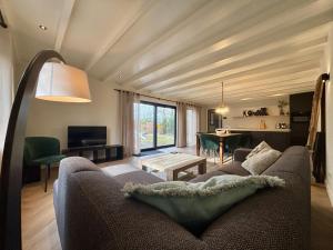 a living room with a couch and a table at Luxe recreatiebungalows midden in bosrijke omgeving Waalre Noord-Brabant in Waalre