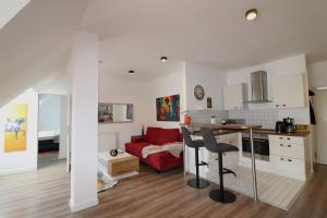 a kitchen and living room with a red couch at Altstadt Suites am Kamp, Parkhaus möglich in Paderborn