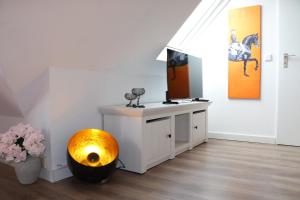 a room with a television and a table with a bowl at Altstadt Suites am Kamp, Parkhaus möglich in Paderborn +16 photos