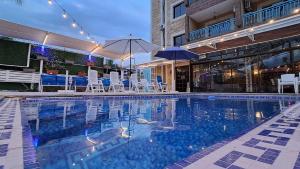 a swimming pool with chairs and umbrellas in a building at Byblos inn, jbeil ,Fidar in Al Fīdār