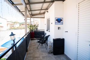 ein Balkon eines Hauses mit Stühlen und einem Tisch in der Unterkunft Zeffie's Studio in Olympiada